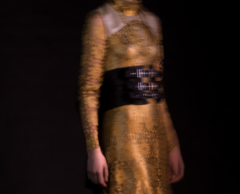 Golden lace dress with black corset belt in movement by Haruco-vert - Fashion photography by Ruud van Ooij