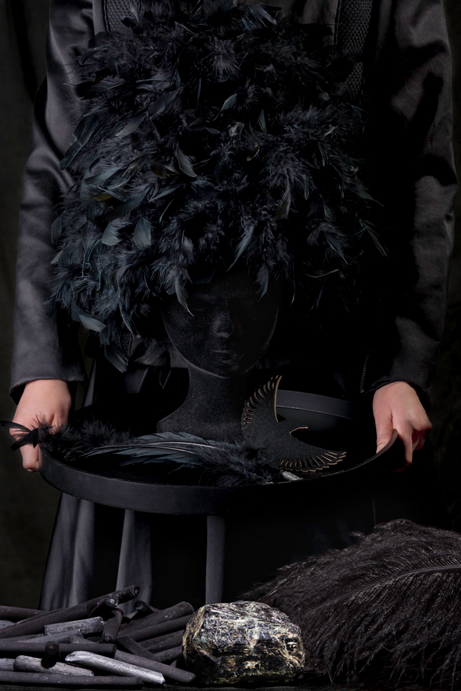 Black coat withblack feather headpiece charcoal symbolism - Fashion still life Ruud van Ooij